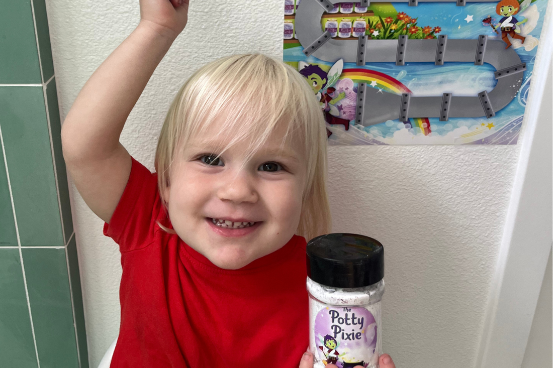 Toddler smiling while sprinkling potty pixie reward pixie ust.