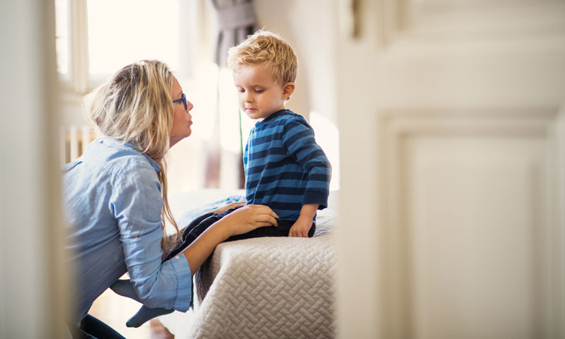 Parent comforting toddler after potty accident