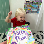 Child holding a book titled 'The Potty Pixie' in a bathroom setting.